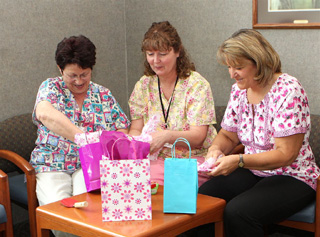 Leona Marie, Kelly Sheppard and Char Arnzen, staff members from St. Marys Hospital Cottonwood Clinic, help stuff Luau goody bags for the July 27th Komen for the Cure Ladies Night Out. Appointments can be made for a wellness exam by calling, 962-3267.
